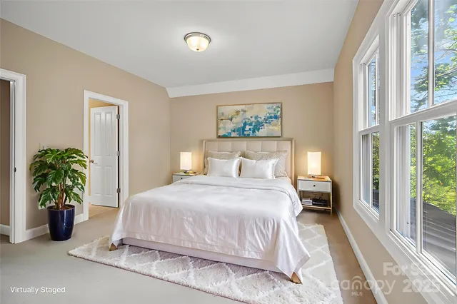 a bedroom with a bed table and a large window