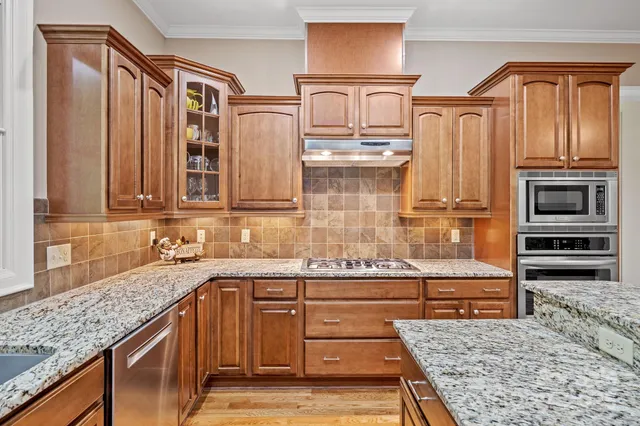 a kitchen with stainless steel appliances granite countertop a stove and cabinets