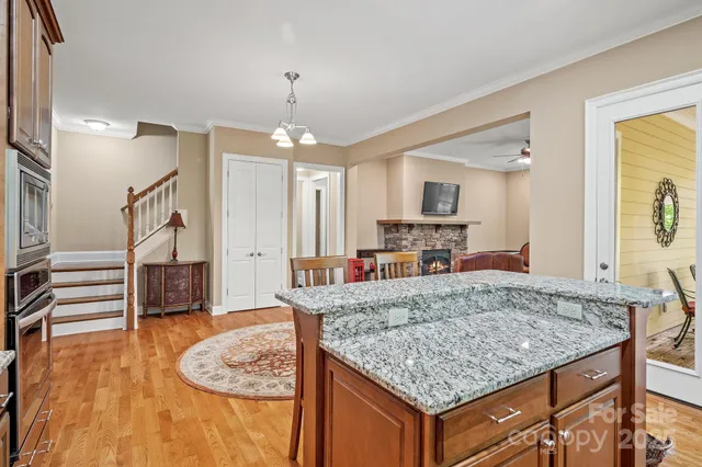 a kitchen with kitchen island granite countertop a counter space dining table and stainless steel appliances