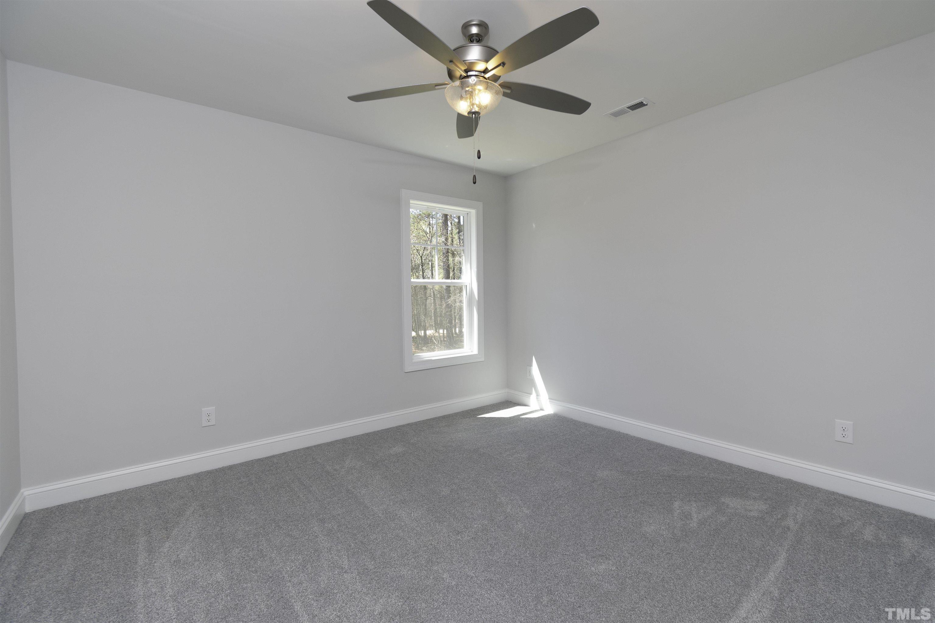 2758 Sledge Road Louisburg, NC 27549 - Photo 24 of 38 an empty room with a window and a fan