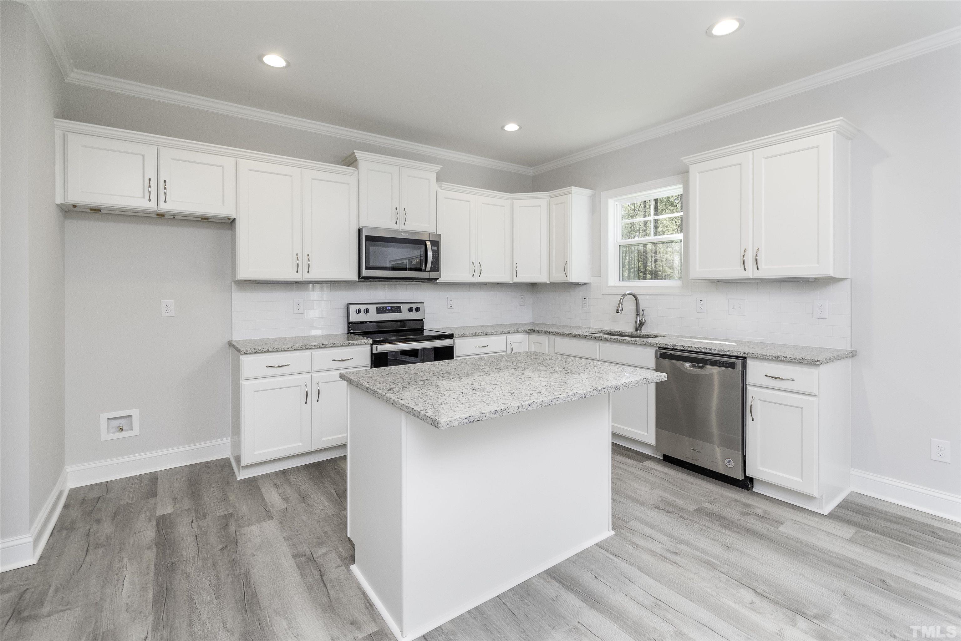 2758 Sledge Road Louisburg, NC 27549 - Photo 7 of 38 a kitchen with stainless steel appliances white cabinets a sink and a stove