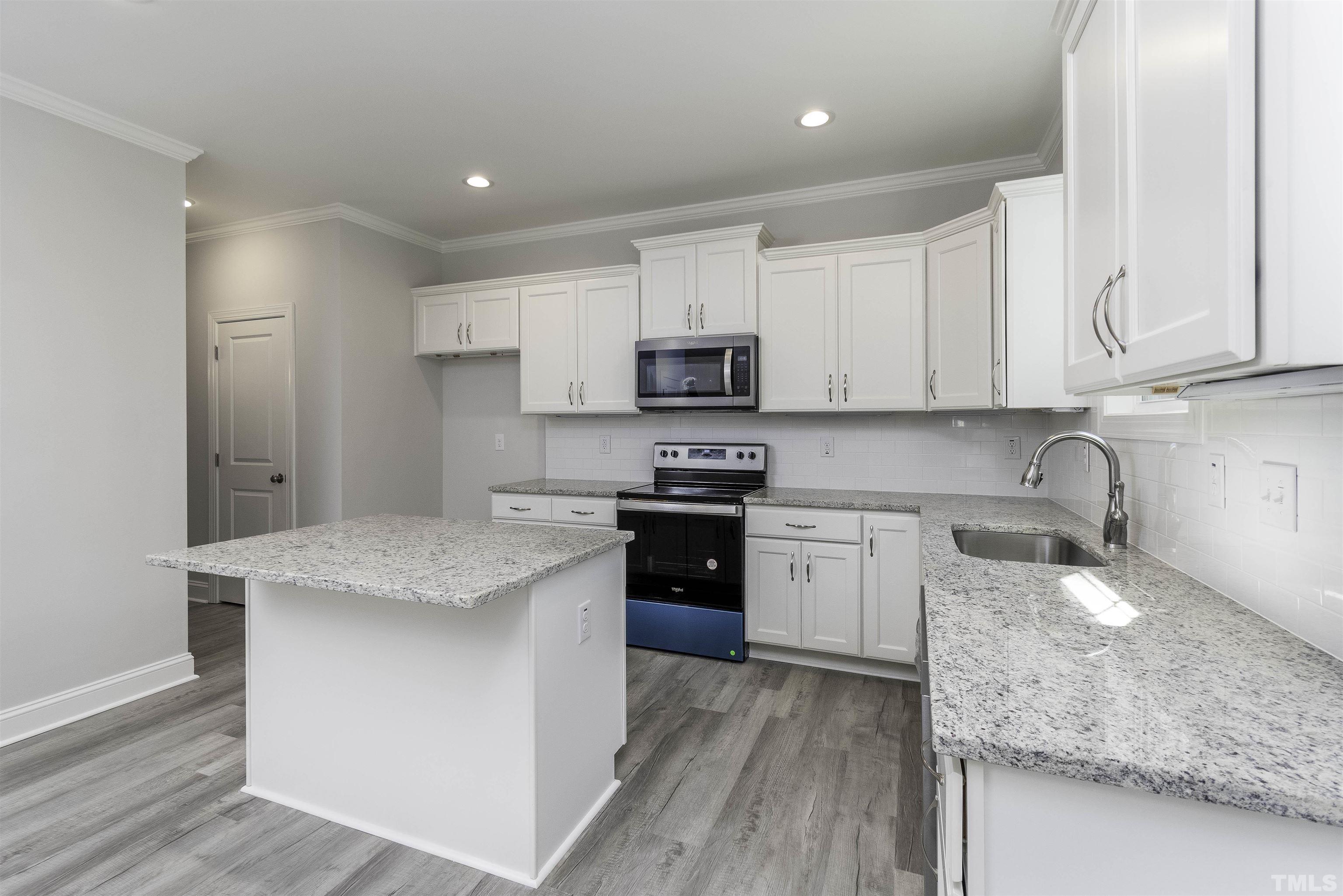 2758 Sledge Road Louisburg, NC 27549 - Photo 8 of 38 a kitchen with granite countertop a sink stove top oven and cabinets
