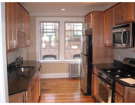 a kitchen with granite countertop a stove a sink and a microwave