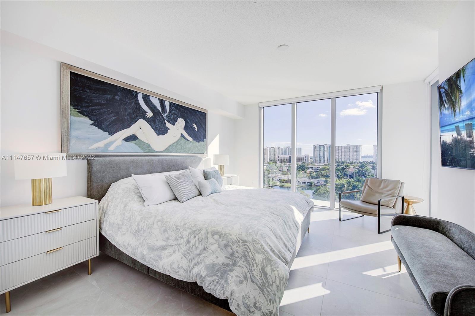 330 Sunny Isles Boulevard, Unit 5802 Sunny Isles Beach, FL 33160 - Photo 13 of 34 a bedroom with a bed couch and two large window