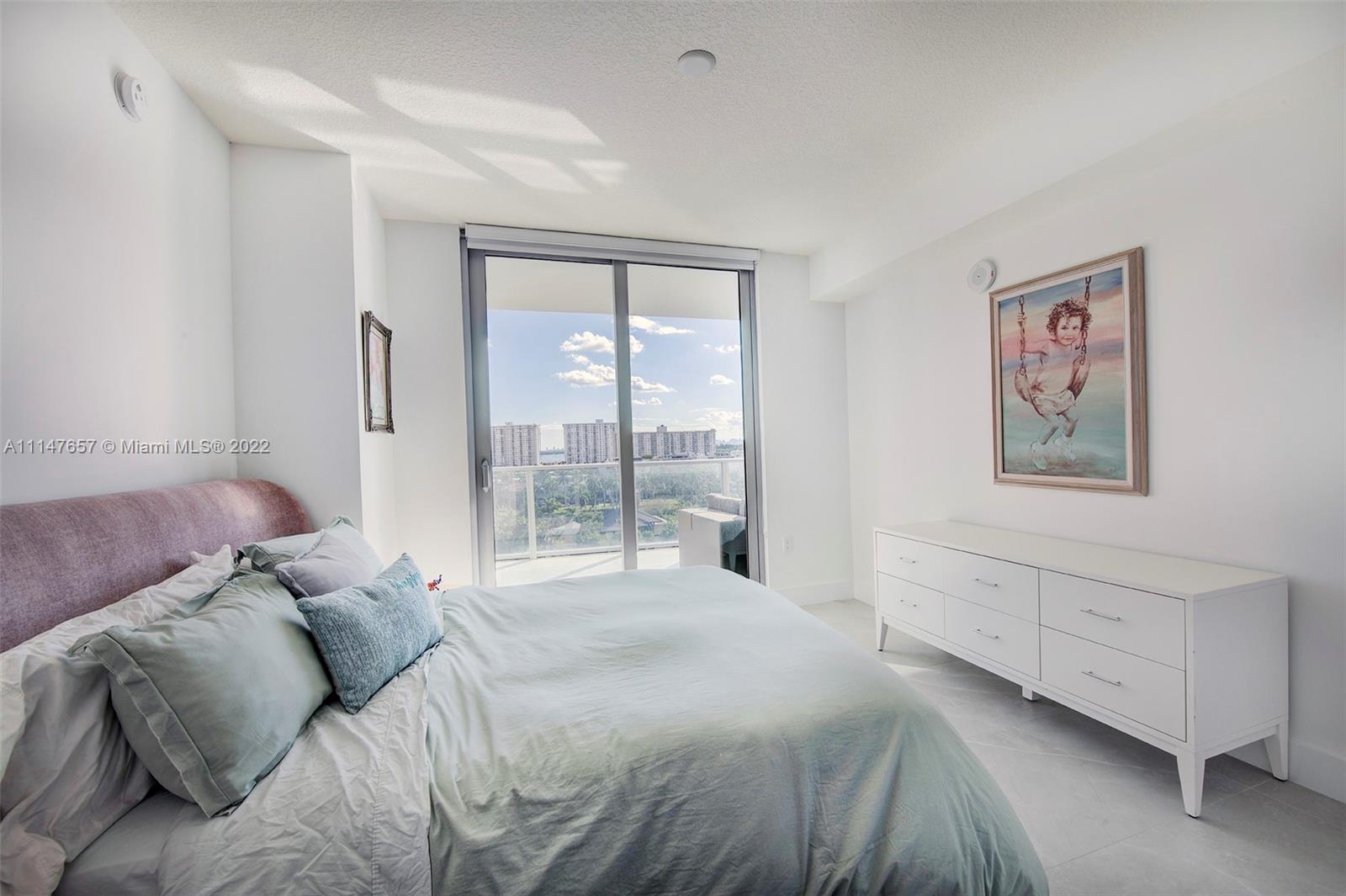 330 Sunny Isles Boulevard, Unit 5802 Sunny Isles Beach, FL 33160 - Photo 18 of 34 a bed room with a bed and a large window