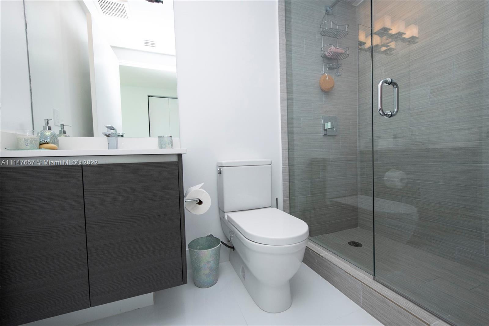 330 Sunny Isles Boulevard, Unit 5802 Sunny Isles Beach, FL 33160 - Photo 19 of 34 a bathroom with a sink toilet and shower