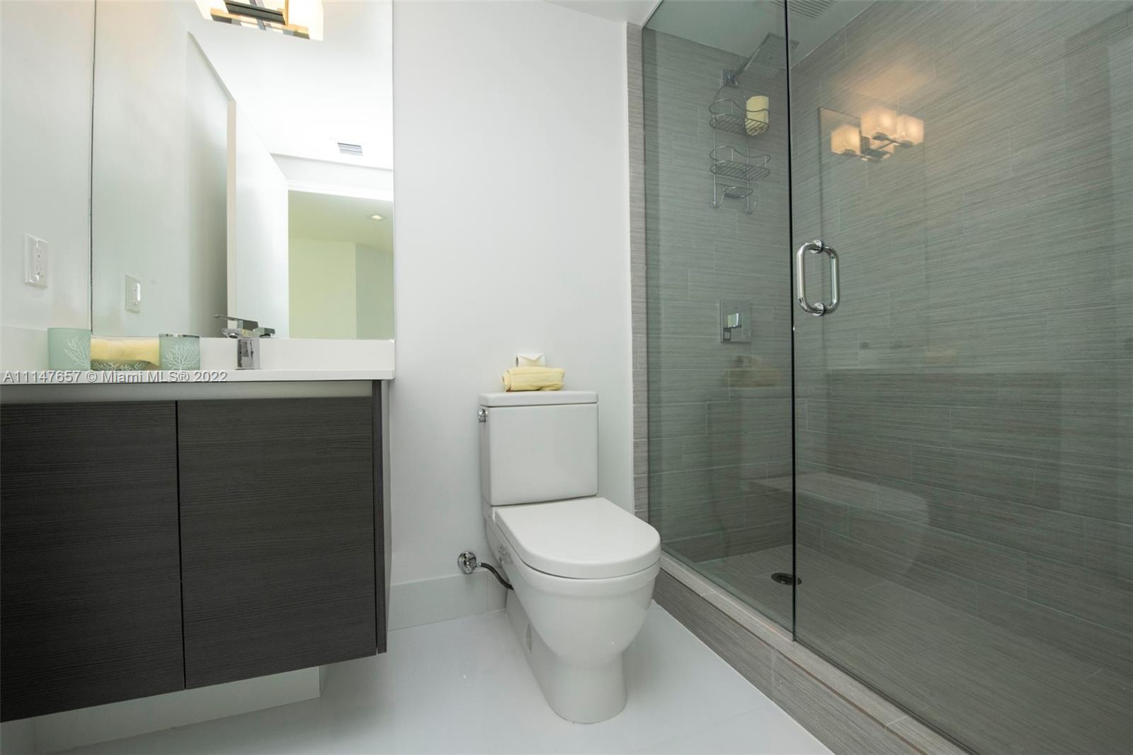 330 Sunny Isles Boulevard, Unit 5802 Sunny Isles Beach, FL 33160 - Photo 22 of 34 a bathroom with a toilet a sink and shower