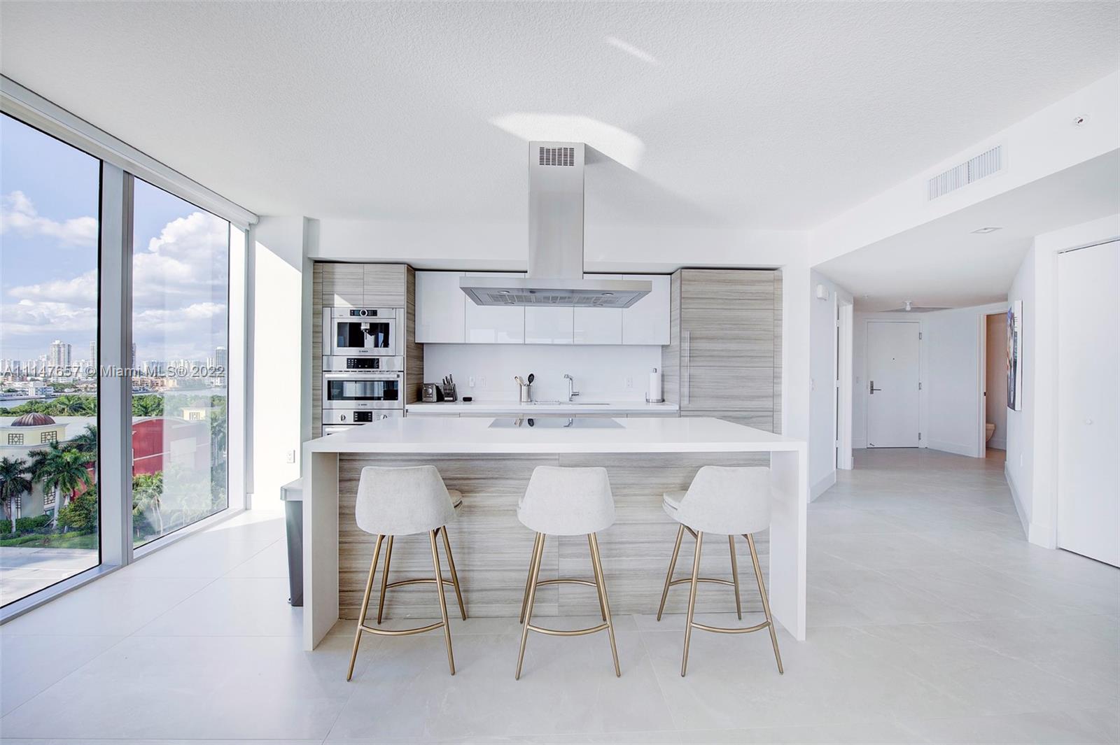 330 Sunny Isles Boulevard, Unit 5802 Sunny Isles Beach, FL 33160 - Photo 5 of 34 a kitchen with a sink and chairs