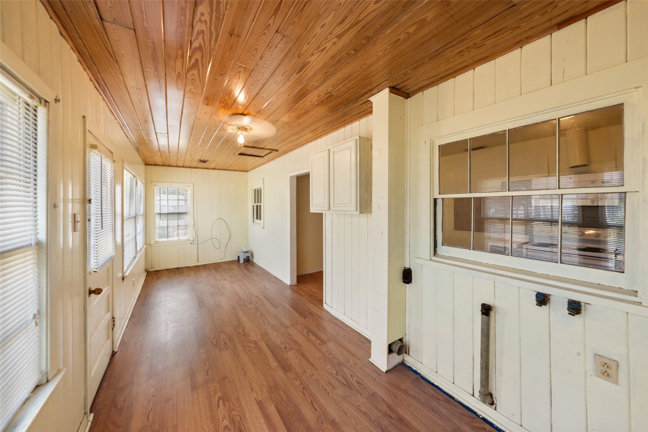 810 Main Street Hempstead, TX 77445 - Photo 23 of 32 Bright enclosed porch/sunroom featuring wood flooring, extensive windows, built-in cabinetry, and flexible additional living space.