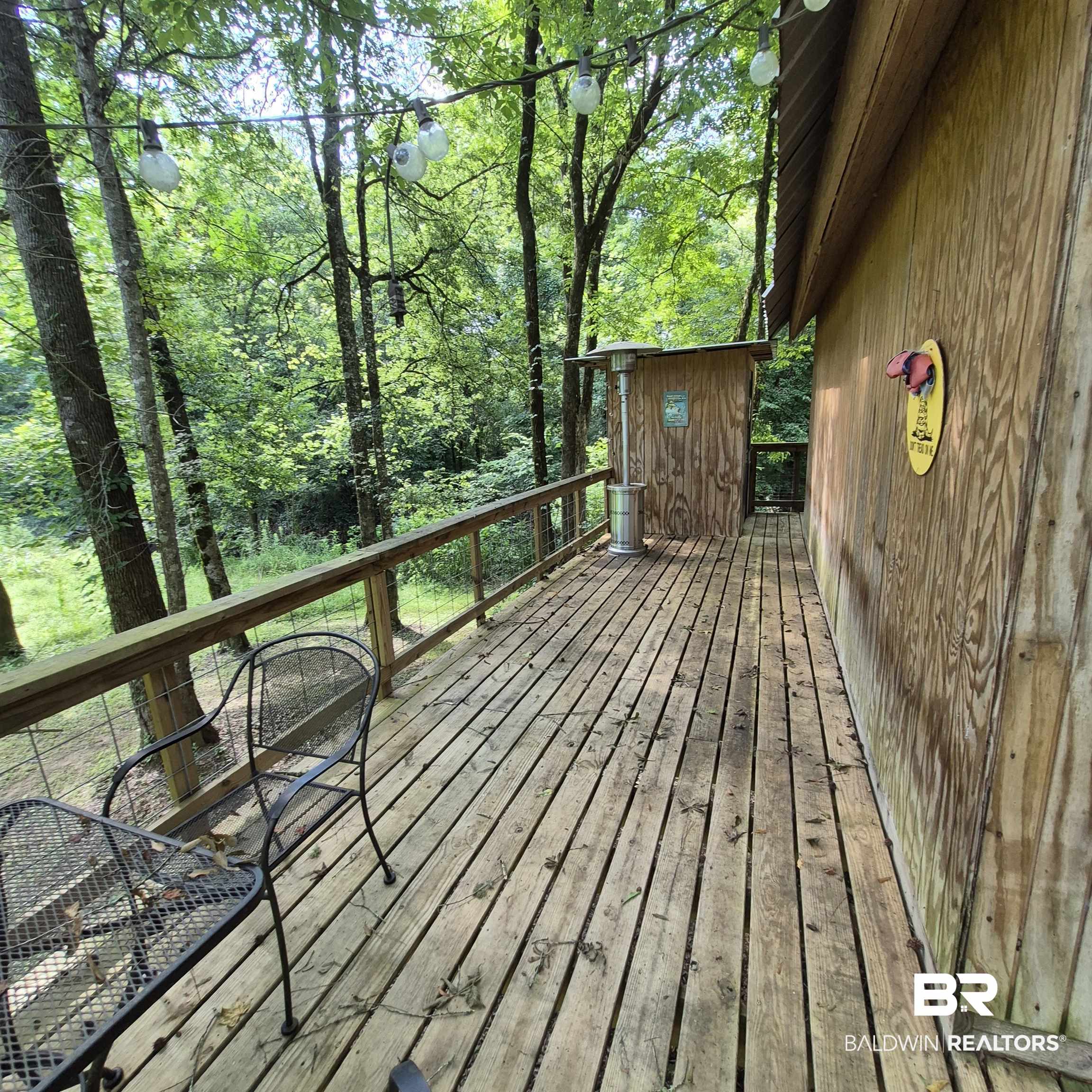 0 Eureka Landing Road Uriah, AL 36480 - Photo 12 of 27 Wood-plank outdoor deck with natural wood railing and wire infill, surrounded by mature trees