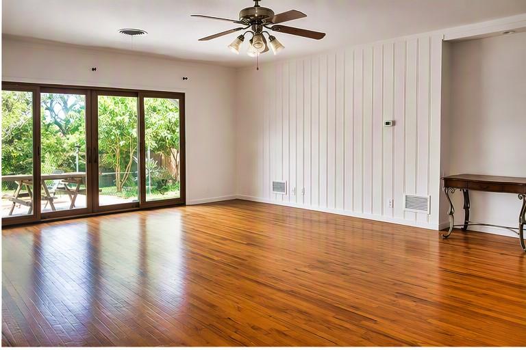 5108 Crown Road Fort Worth, TX 76114 - Photo 22 of 22 Spacious interior featuring wood-finish flooring, a ceiling fan with integrated lighting, and a white vertical paneled accent wall