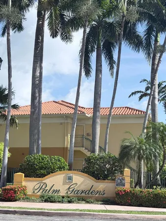 front view of a house with a yard and palm trees