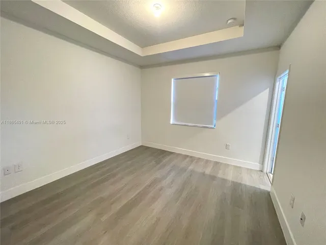 an empty room with a hardwood and door