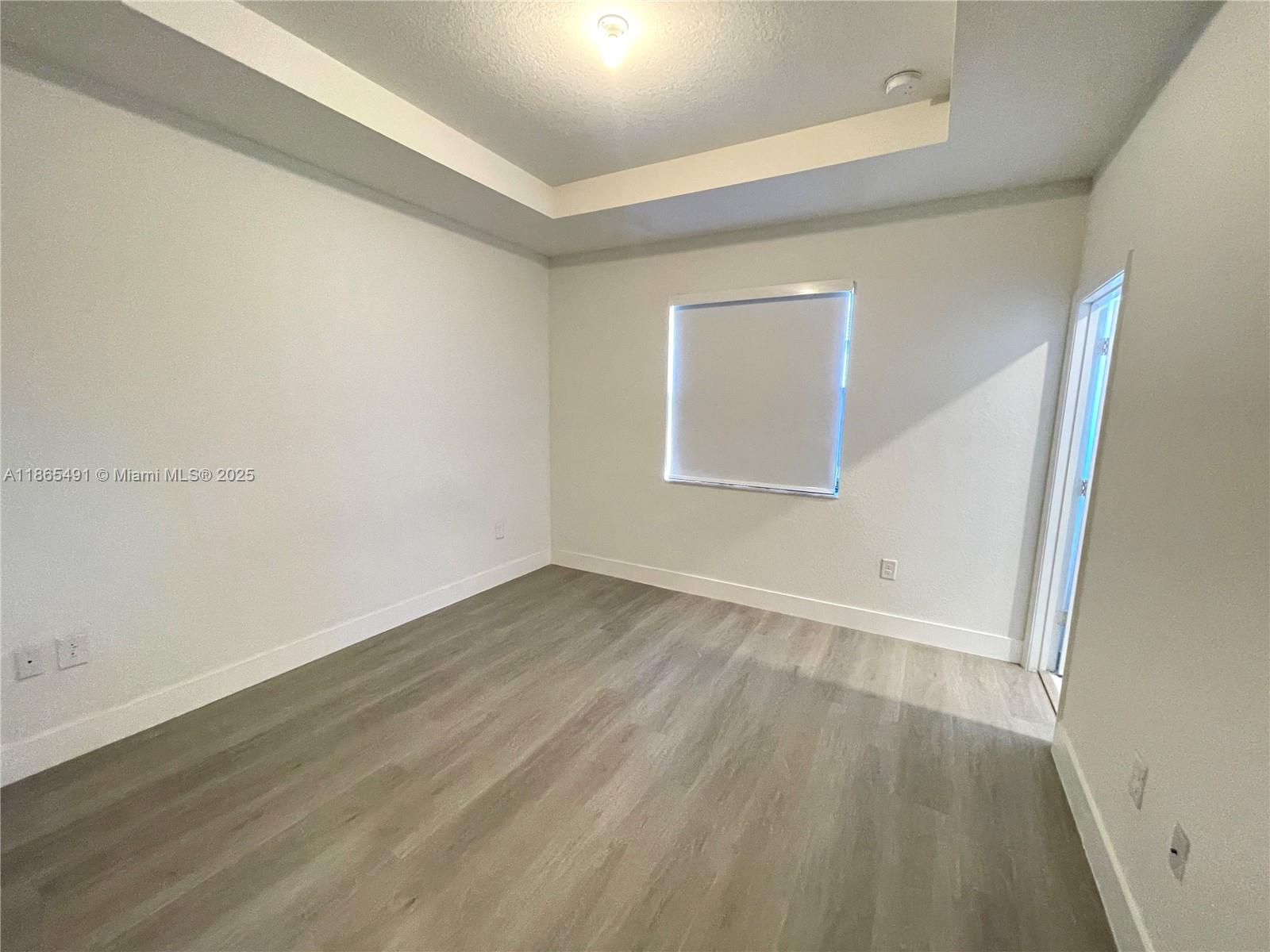 23269 Southwest 129th Path, Unit 23269 Miami, FL 33186 - Photo 14 of 20 an empty room with wooden floor and windows