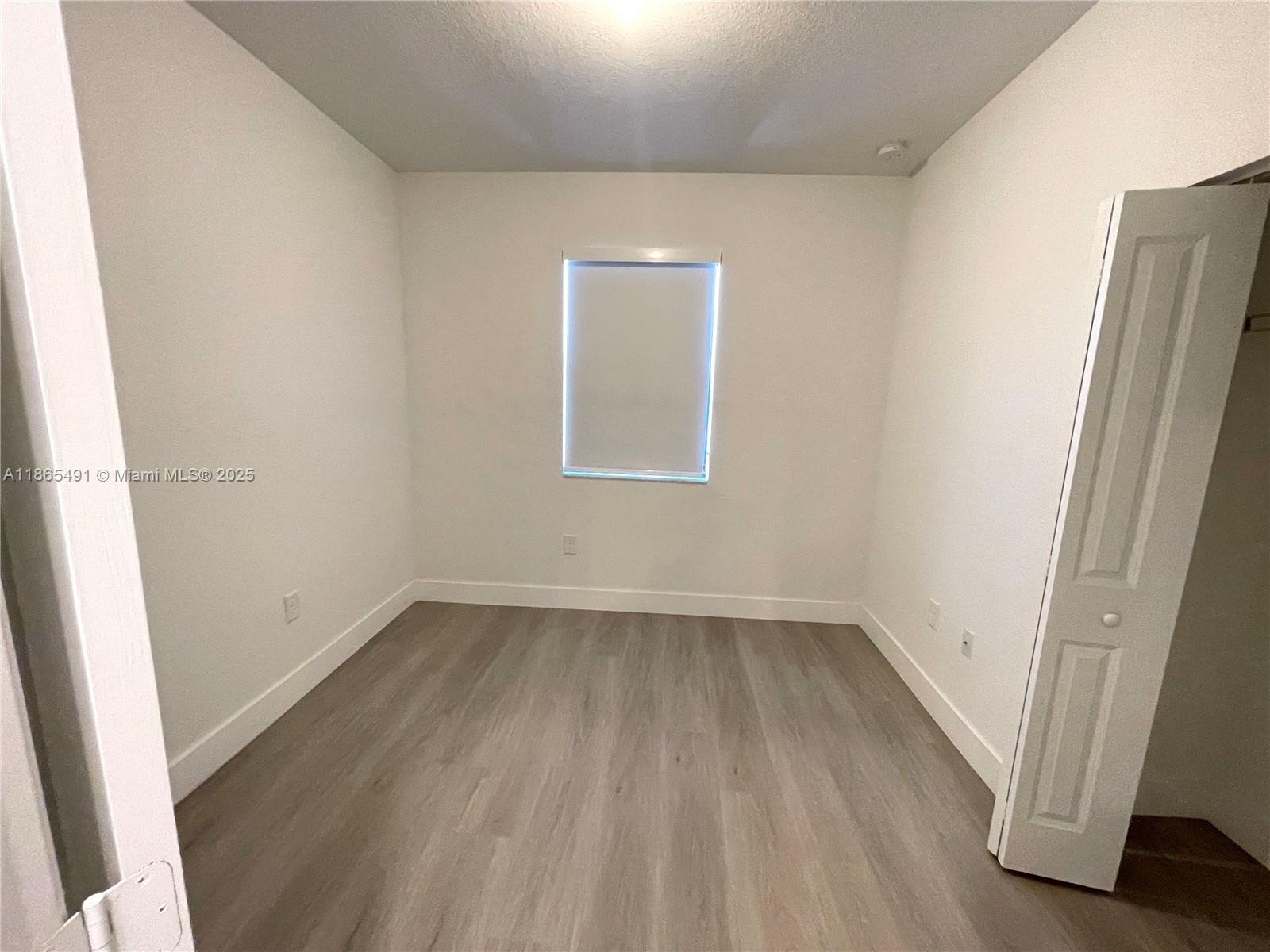 23269 Southwest 129th Path, Unit 23269 Miami, FL 33186 - Photo 15 of 20 an empty room with a hardwood and door