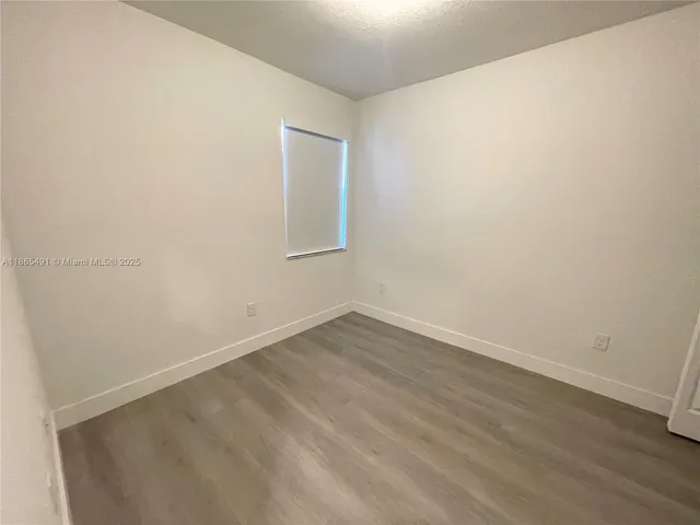 an empty room with wooden floor and closet