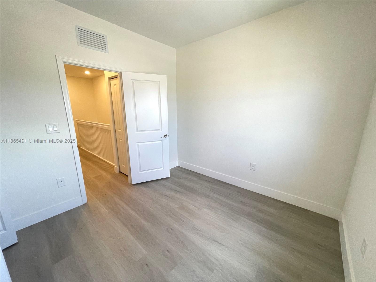 23269 Southwest 129th Path, Unit 23269 Miami, FL 33186 - Photo 17 of 20 an empty room with wooden floor and closet