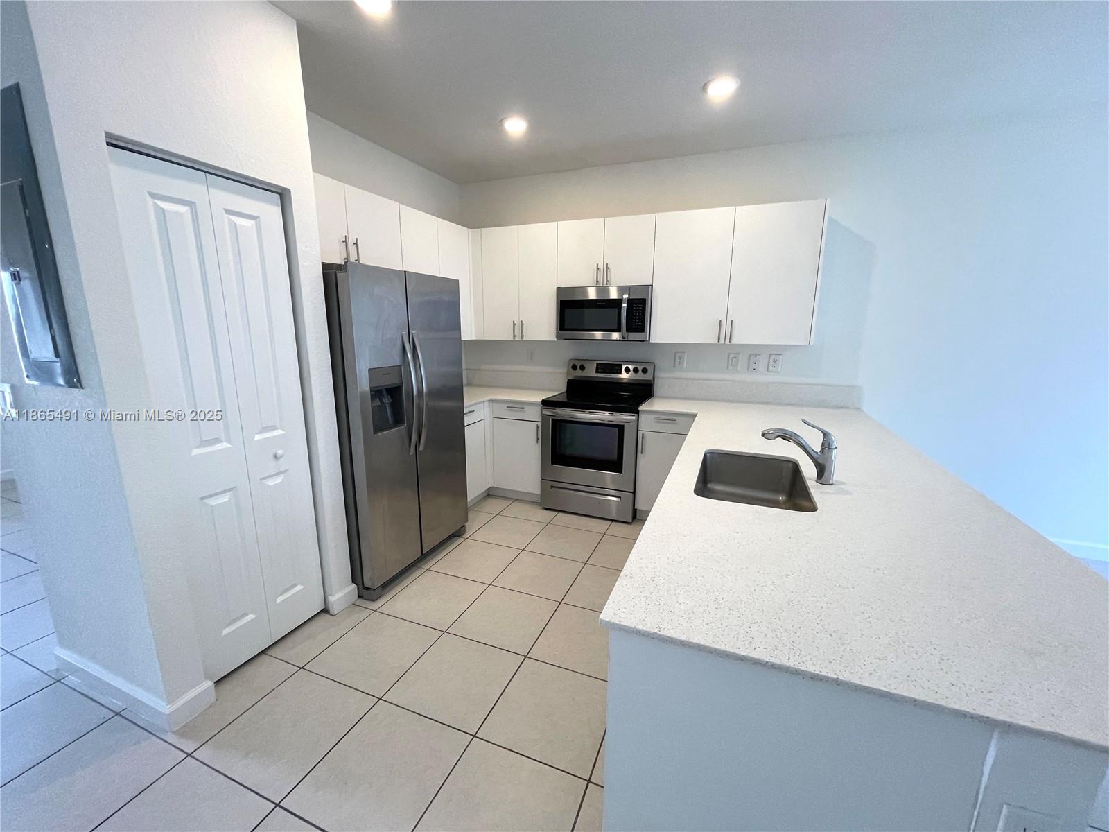 23269 Southwest 129th Path, Unit 23269 Miami, FL 33186 - Photo 6 of 20 a kitchen with stainless steel appliances a refrigerator sink and microwave