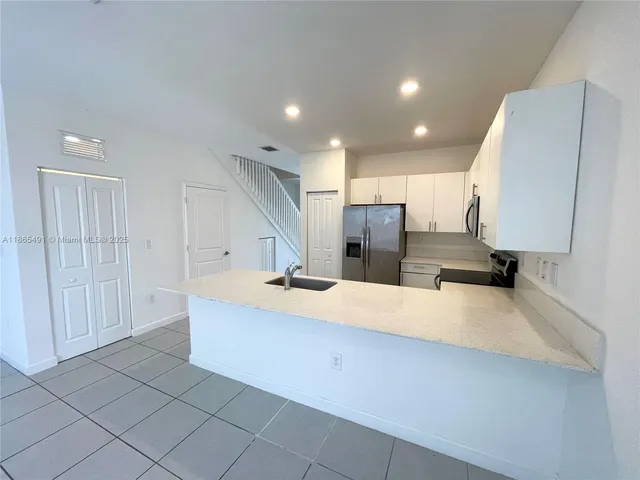 a large kitchen with a large counter top sink and cabinets