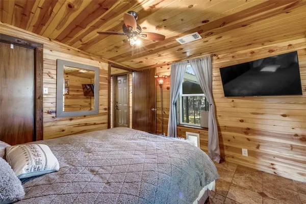 a bedroom with a bed and a flat tv screen in it