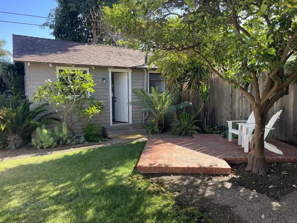 a view of a patio with table and chairs potted plants and large tree