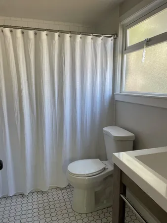 a white toilet sitting next to a shower