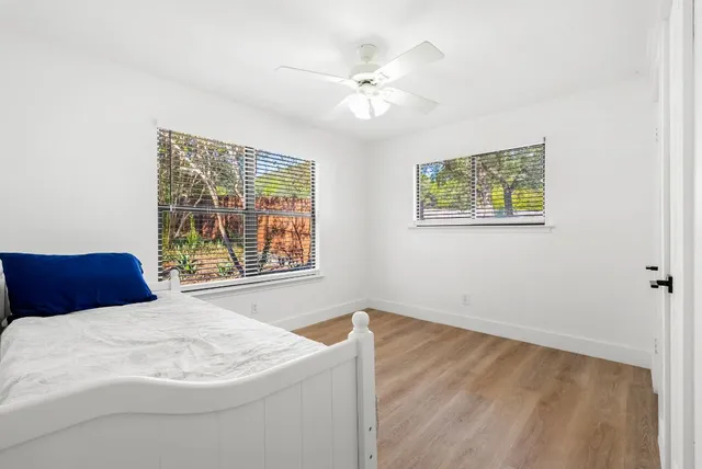 a bed sitting in a bedroom next to a window