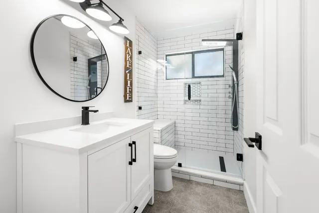 a bathroom with a sink a toilet and a mirror