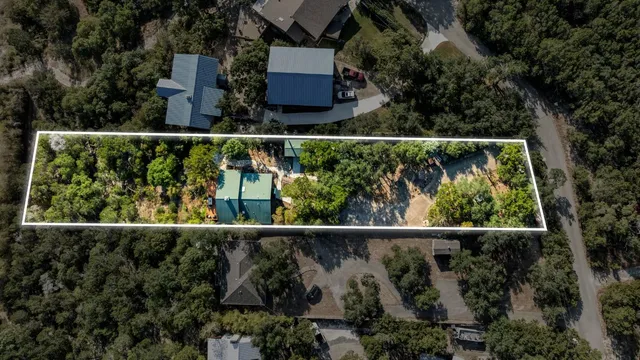 an aerial view of a house with a yard and lake view