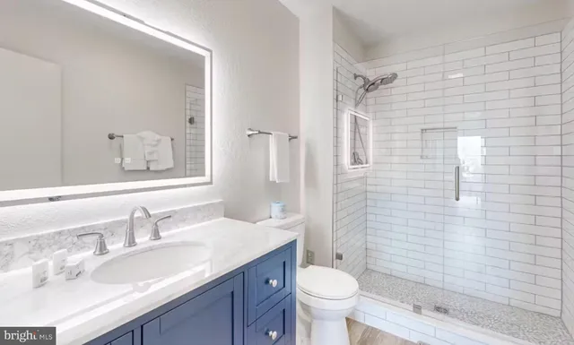 a bathroom with a granite countertop sink toilet and shower