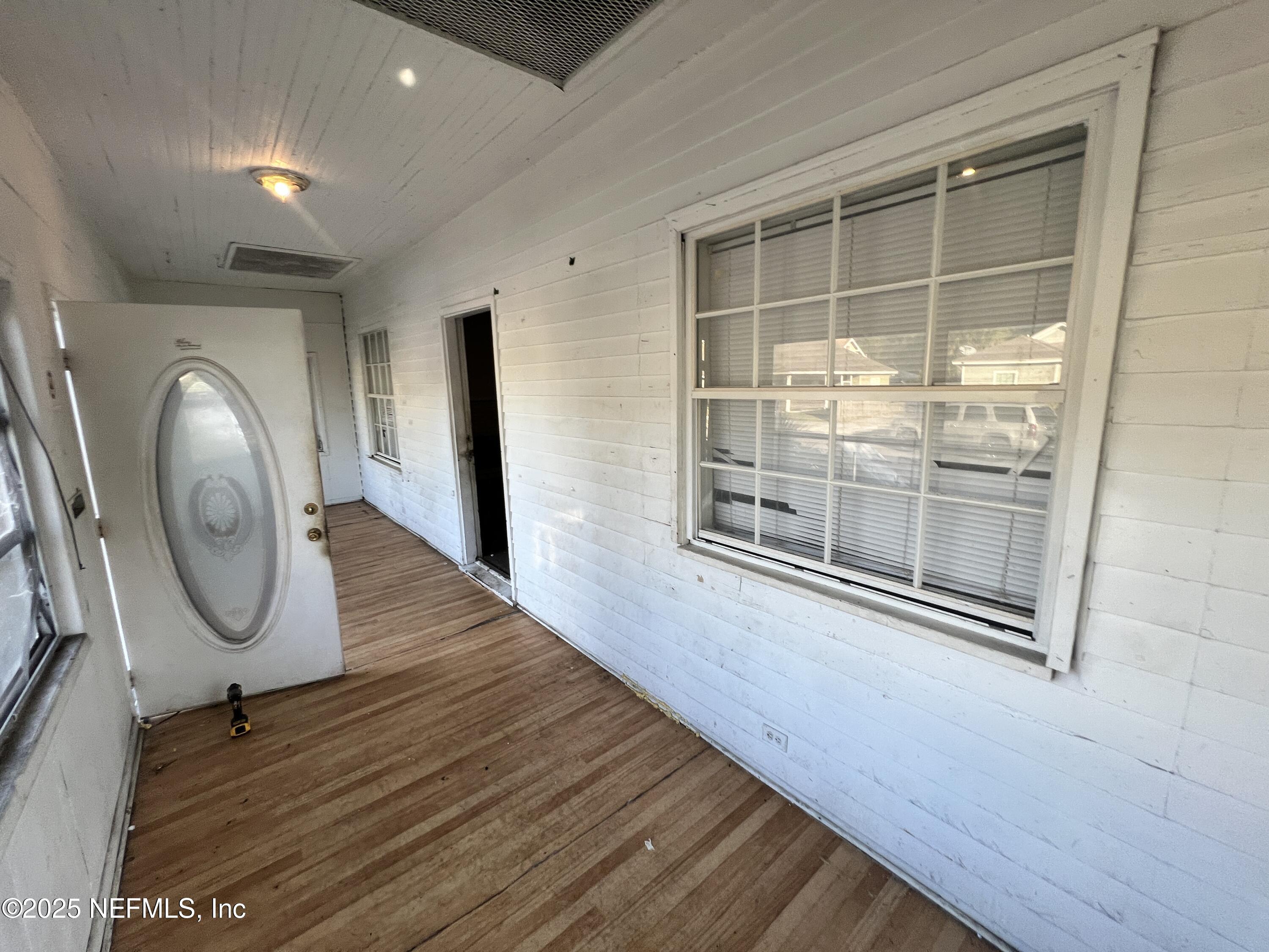 408 West 23rd Street Jacksonville, FL 32206 - Photo 10 of 45 an empty room with wooden floor mirror and windows