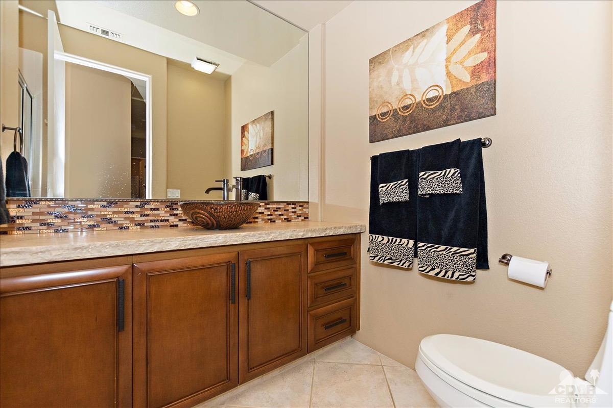 48010 Vía Vallarta La Quinta, CA 92253 - Photo 18 of 37 a bathroom with a granite countertop sink mirror vanity and toilet
