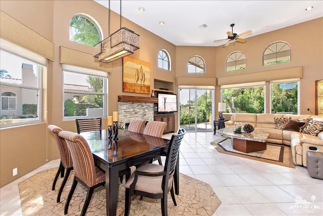 a dining room with furniture a large window and a chandelier