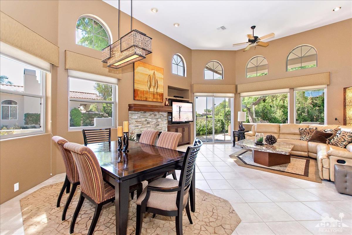 48010 Vía Vallarta La Quinta, CA 92253 - Photo 7 of 37 a dining room with furniture a large window and a chandelier