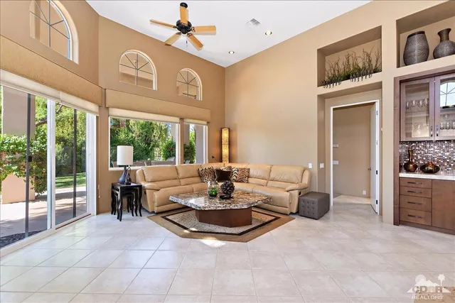 a living room with fireplace furniture and a large window