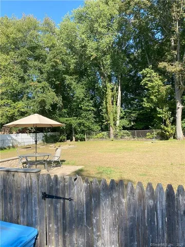 a view of a backyard with wooden floor and fence