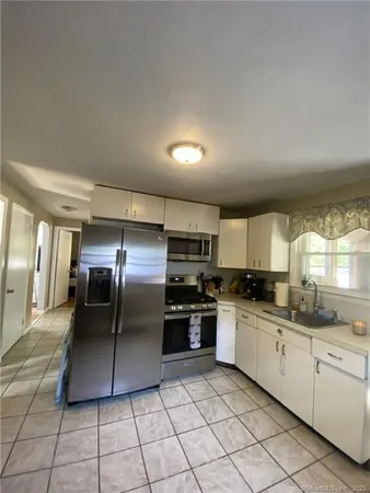 a kitchen with stainless steel appliances granite countertop a refrigerator a sink a stove with cabinets