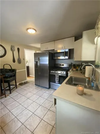 a kitchen with refrigerator and chairs