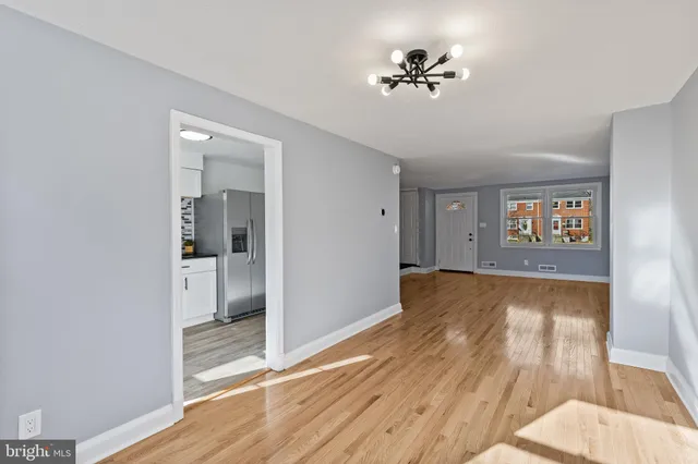 a view of a room with wooden floor and a ceiling fan