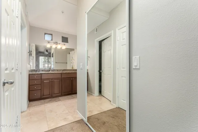 a bathroom with a granite countertop sink a mirror and a shower