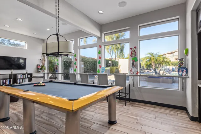 a room with pool table and windows