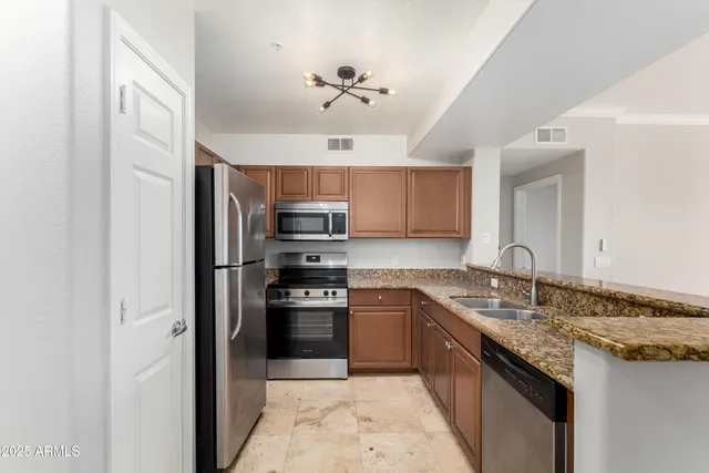 a kitchen with stainless steel appliances granite countertop a sink stove and refrigerator