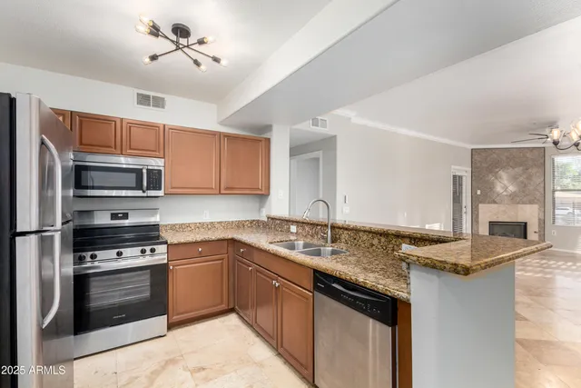 a kitchen with stainless steel appliances granite countertop a sink stove and refrigerator