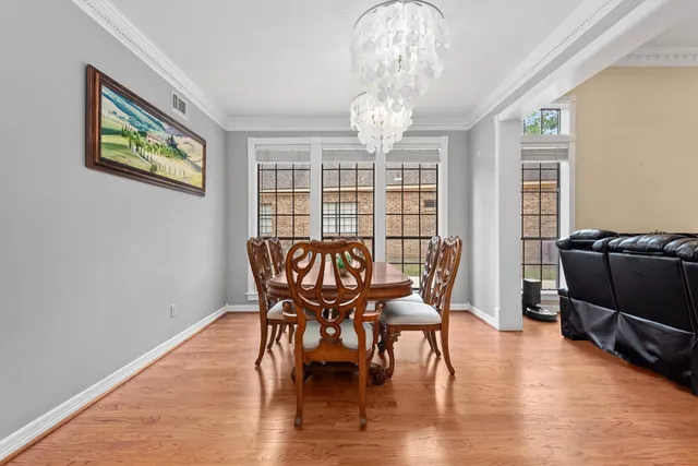 a view of a dining room with furniture a chandelier and wooden floor