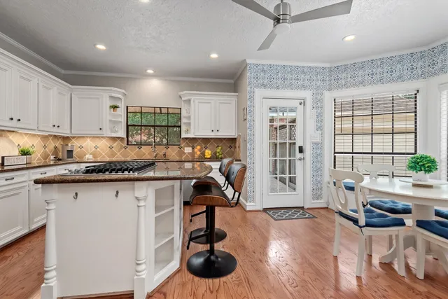 a kitchen with granite countertop a stove a sink and a refrigerator