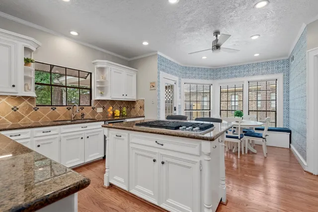 a kitchen with granite countertop stove a sink and wooden floors
