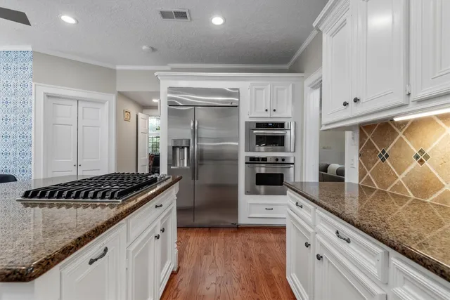 a kitchen with stainless steel appliances granite countertop a sink and cabinets
