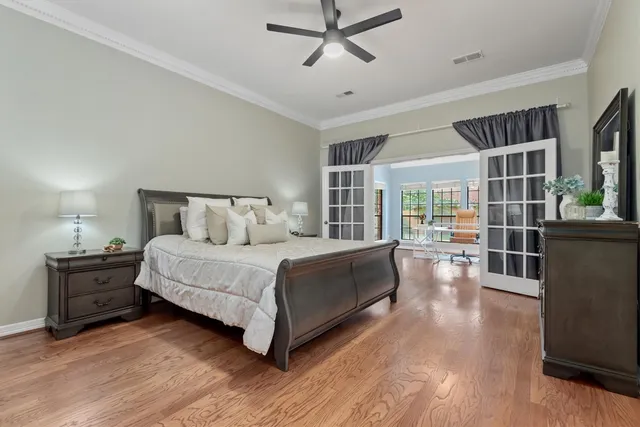 a spacious bedroom with a bed and wooden floor