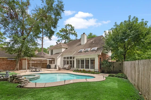 a view of house with swimming pool and next to a yard