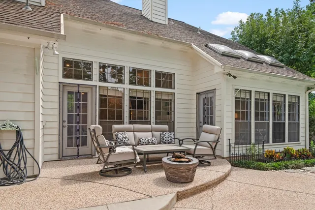 a view of a patio with couple of chairs and a potted plant